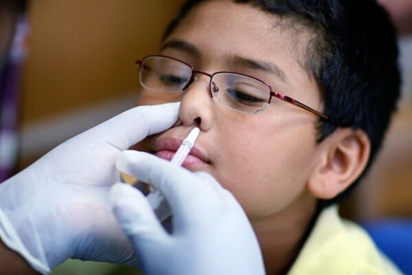 A child receiving a nasal vaccine